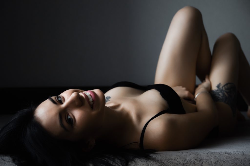 Woman in black bra in dark moody boudoir photo