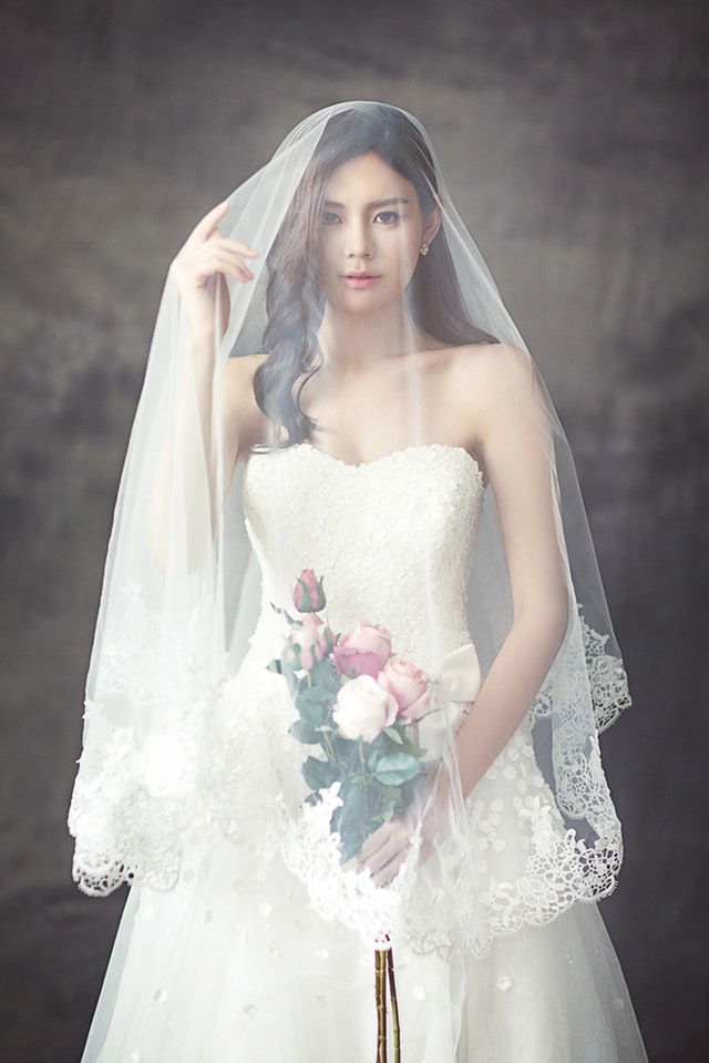Bride in gown and veil holding bouquet